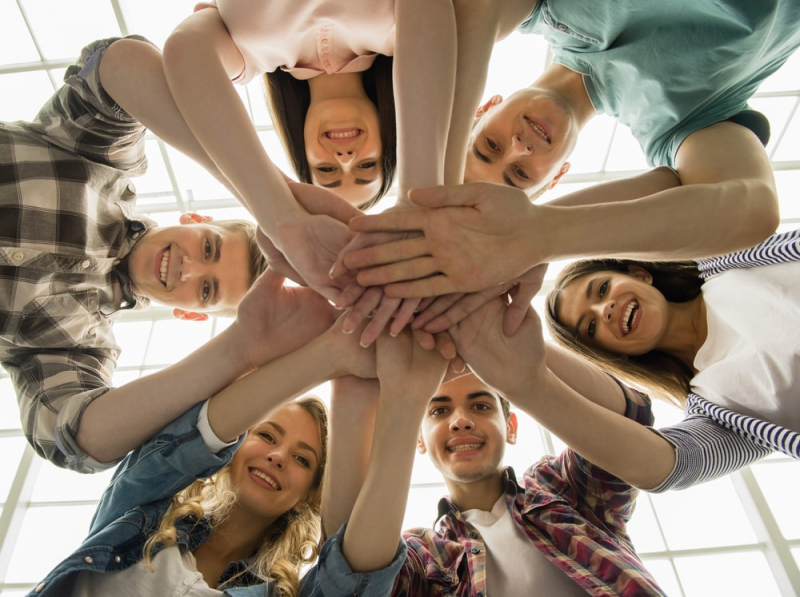 Businesses supporting local communities by workers standing in a circle with linked arms.