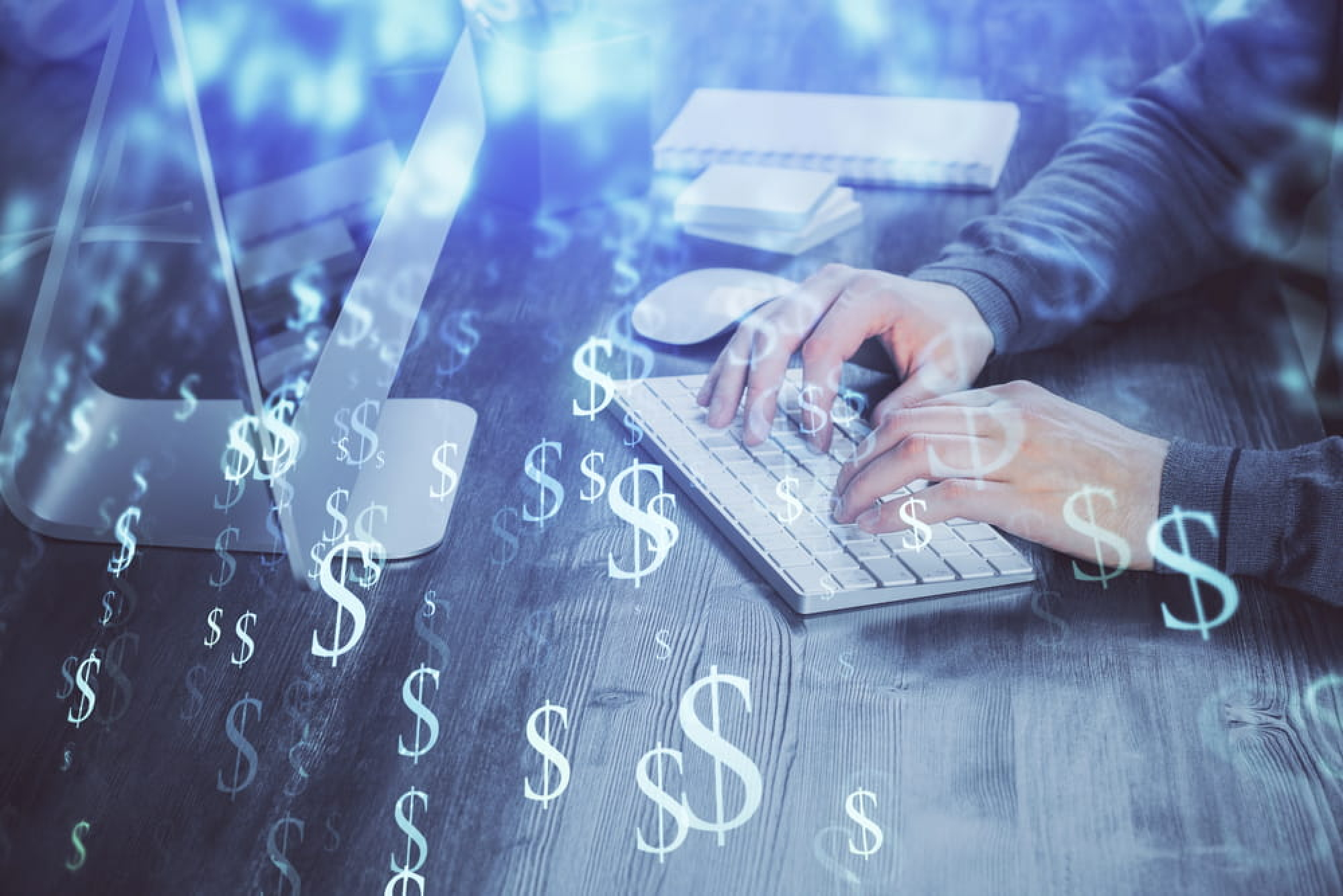 Staff member typing on a keywboard calculating the financial impact of a cyber breach