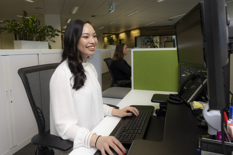 Jenny sitting and working at her desk.