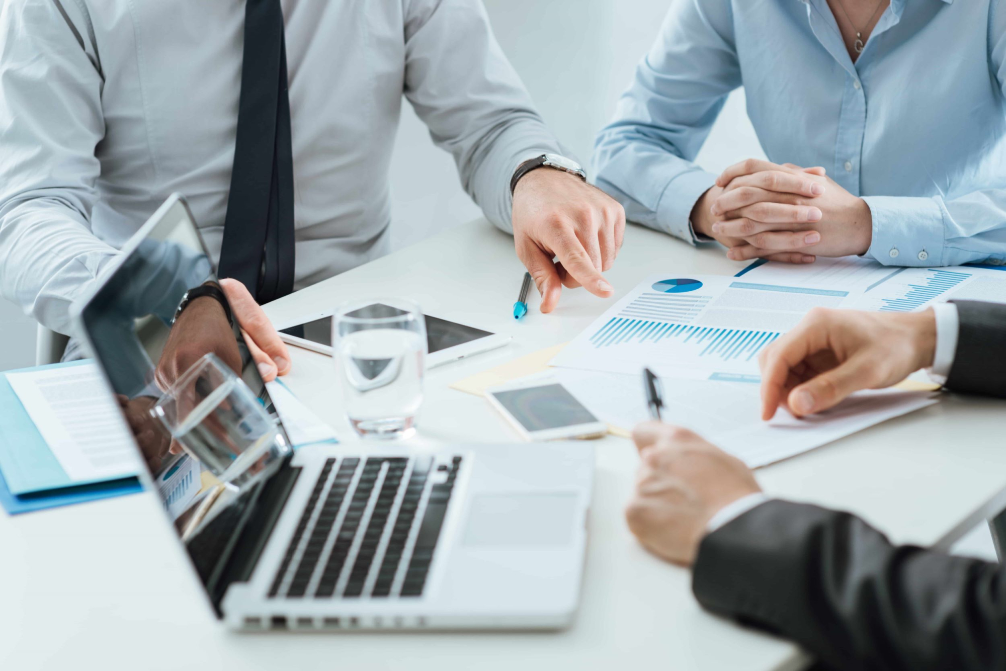 Business people sitting around a table looking at business reults.