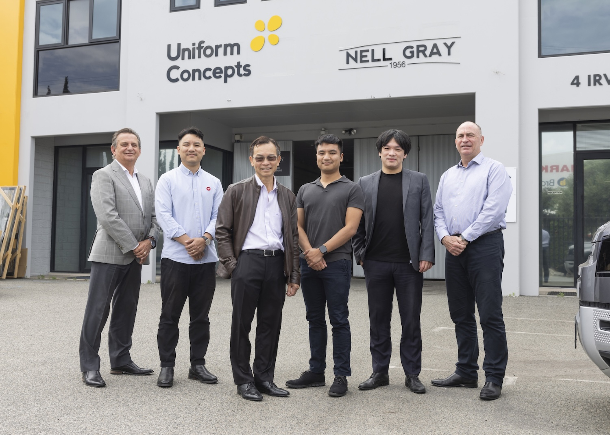 Nell Gray and Ledge Finance teams standing in front of Uniform Concepts building