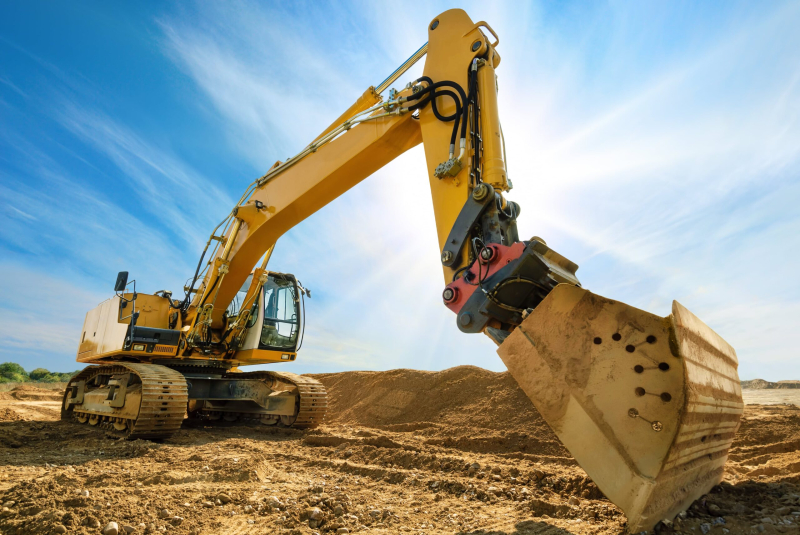 Big excavator in front of the blue sky.