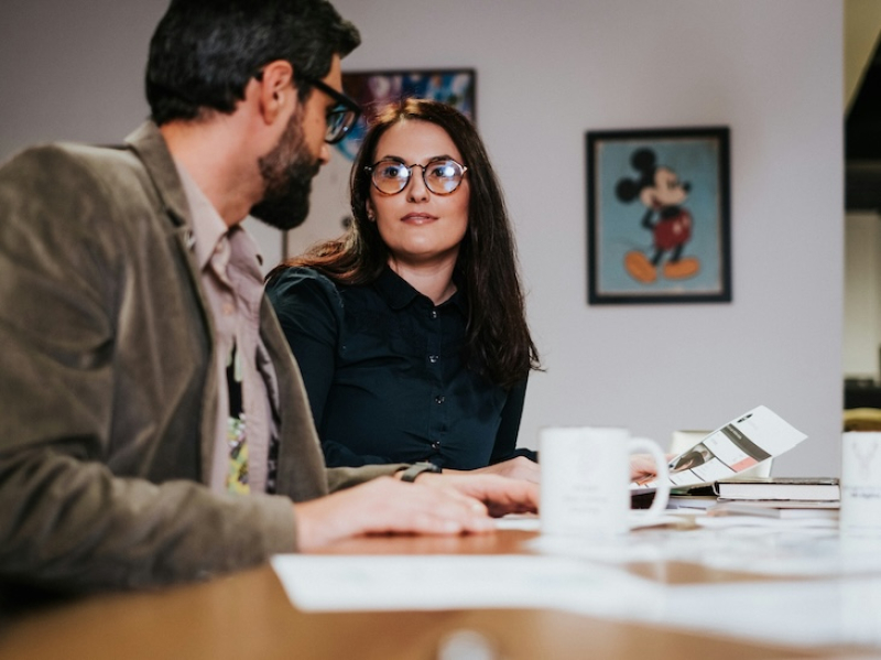 man and woman in a meeting working next to each other at a desk