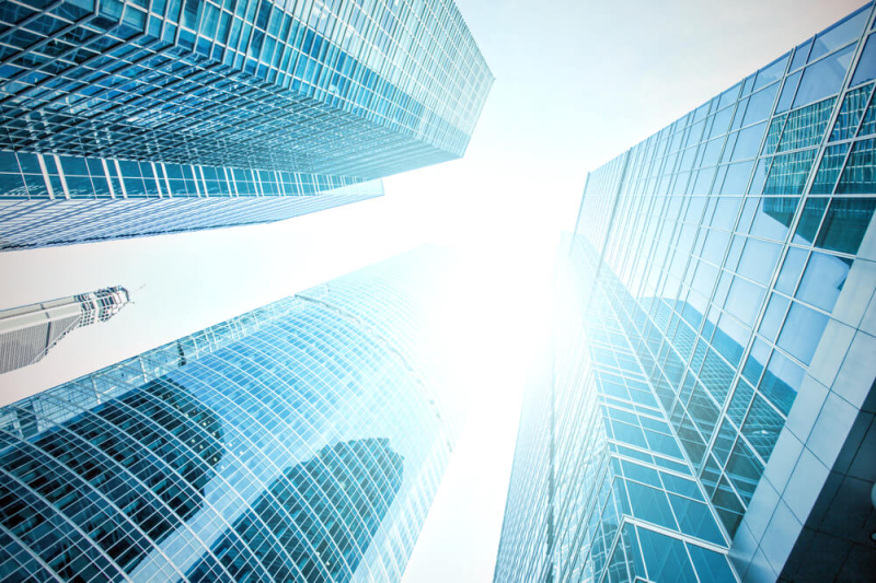 looking up between shining glass commercial buildings depicting the commercial property outlook