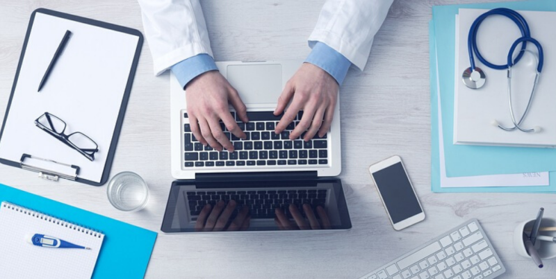 Birds eye view of health professional on laptop. Ledge Finance is here to help with any personal or professional loans for medical professionals.