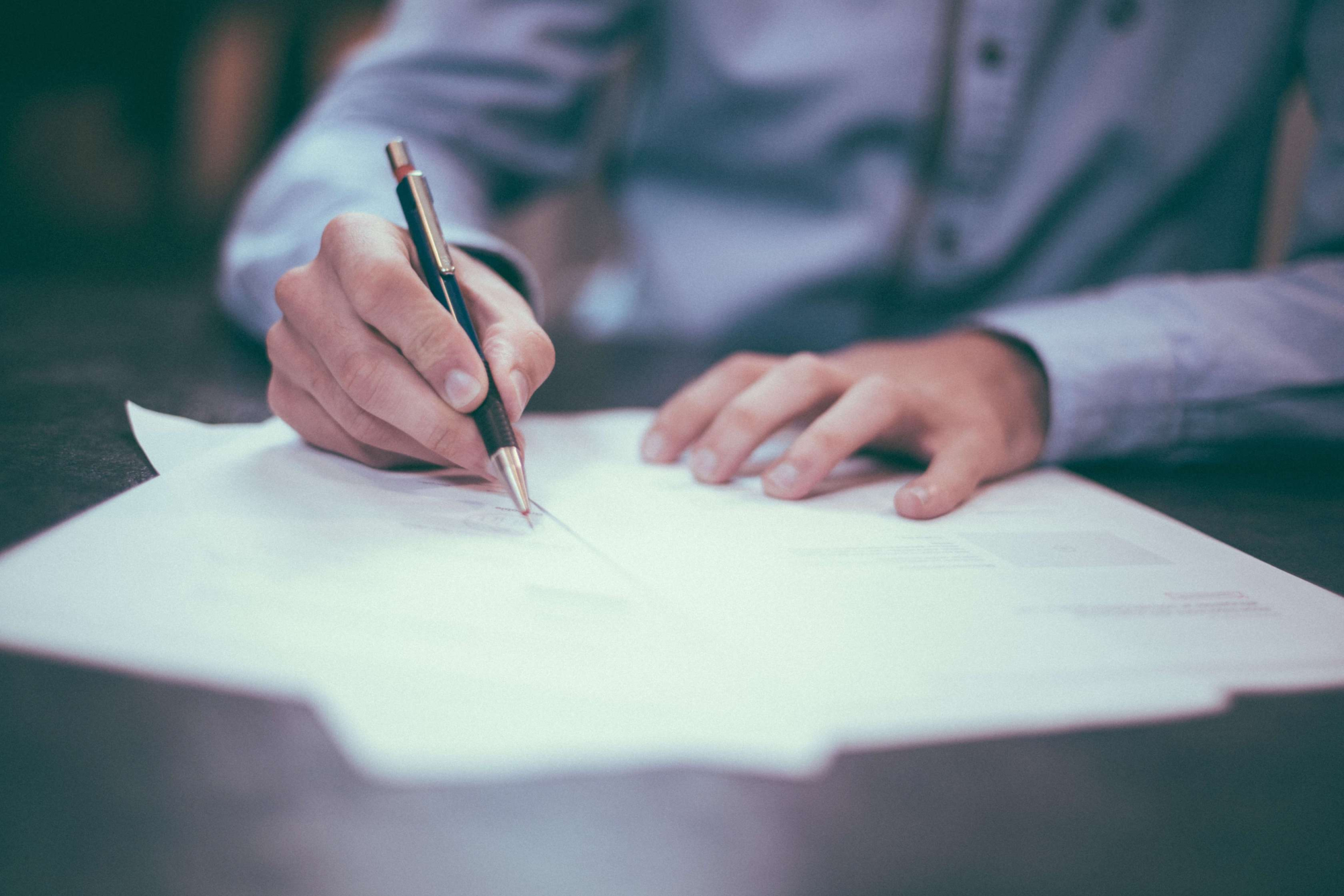 male hands signing paperwork