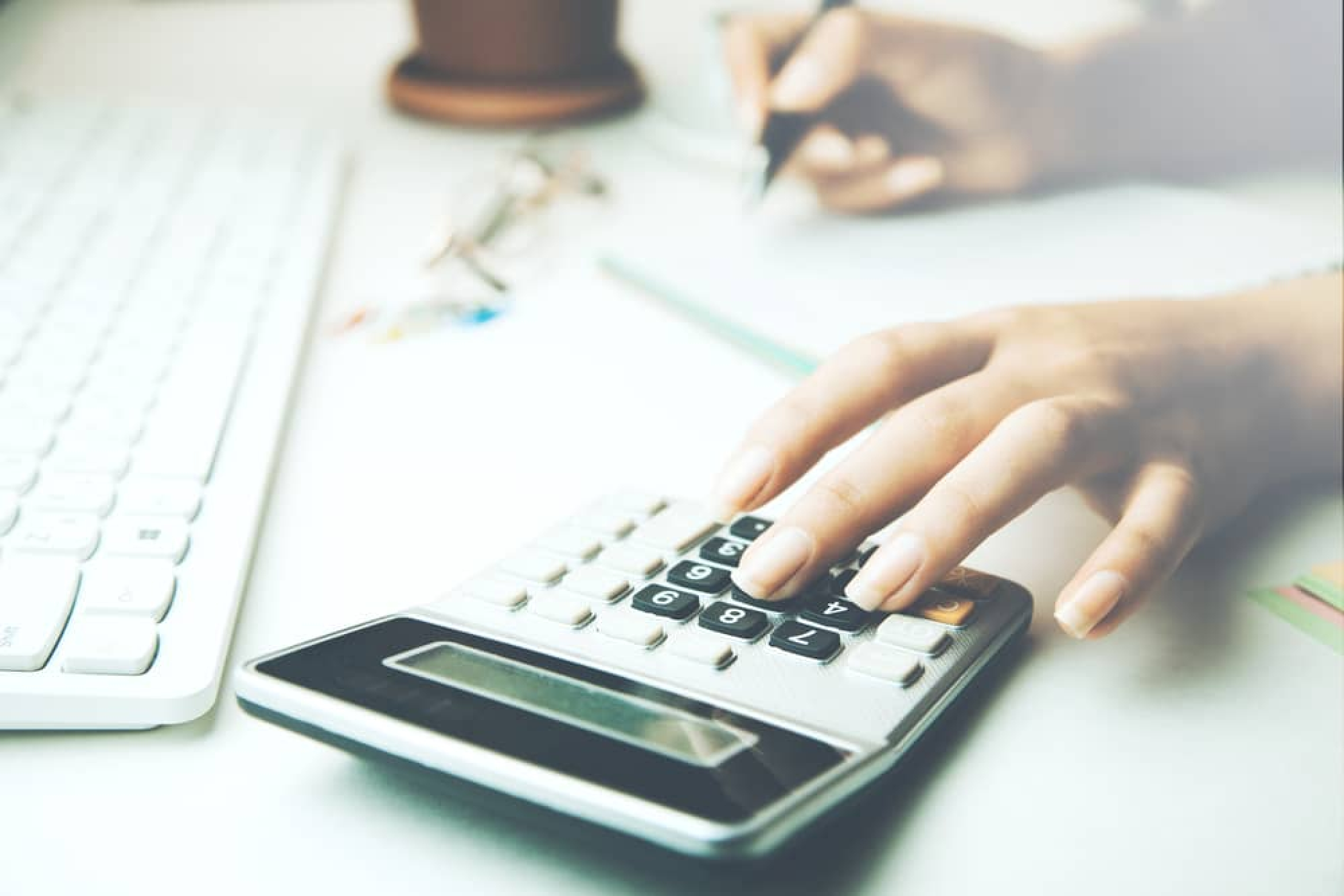 woman using a calculator to work out her business loan refinancing figures