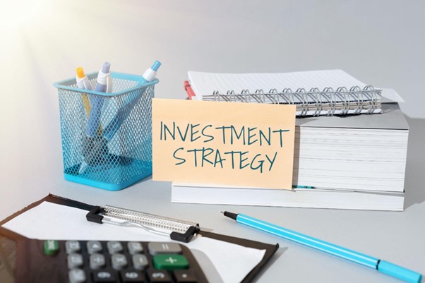 environmental impact investment strategy sign next to a keyword, notepad and pens