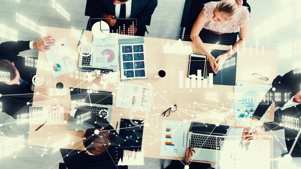 Staff sitting around a table discussing how AI can help their business.