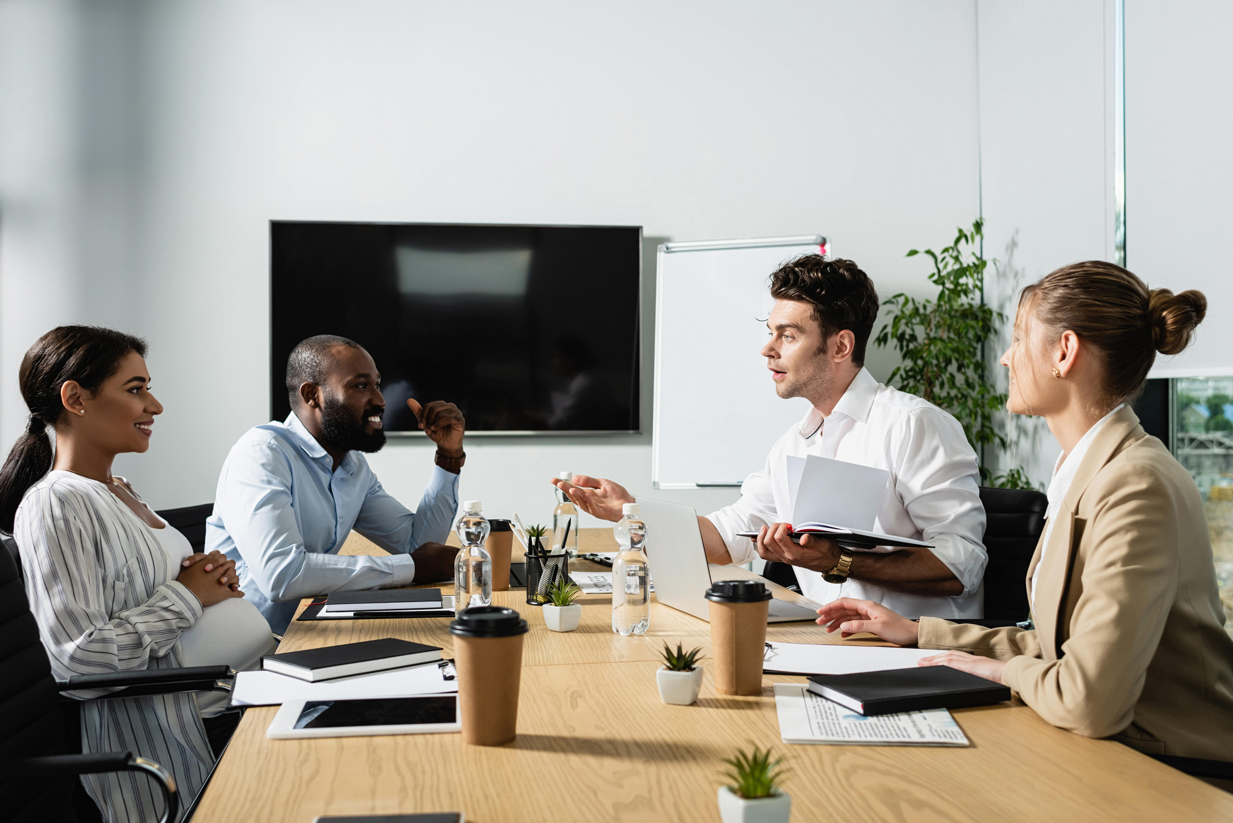 Four people in a boardroom meeting.